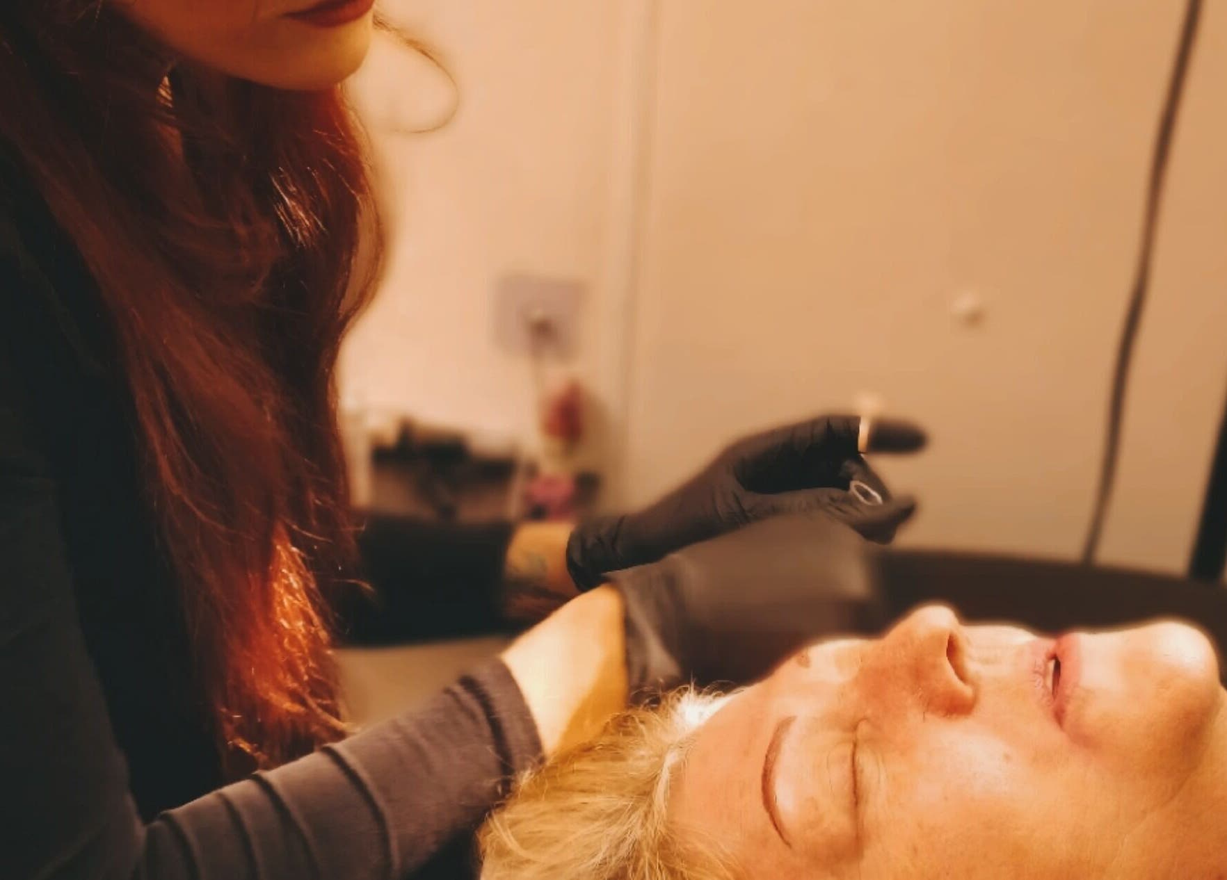 A skilled artist performs eyebrow tattooing at Inked Elegance, Randburg, Gauteng, ZA, ensuring precise results.