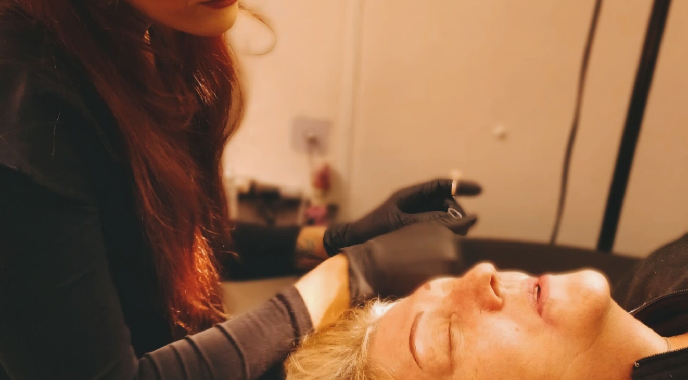 A skilled artist performs eyebrow tattooing at Inked Elegance, Randburg, Gauteng, ZA, ensuring precise results.