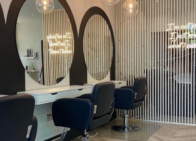 Stylish salon styling area at By.CharleyHulme (Hair) in Leeds, England, GB with sleek black chairs and large round mirrors.