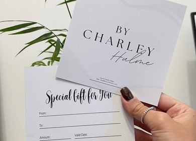 Gift card from By.CharleyHulme (Hair) in Leeds, England, GB, held by hand near a plant.