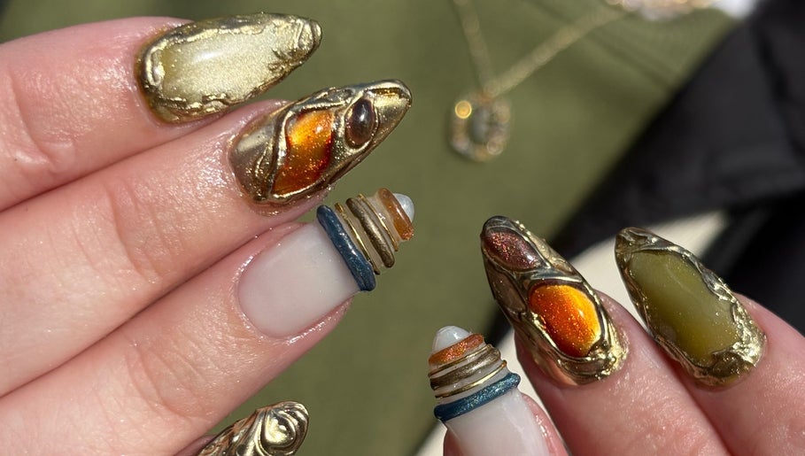 Intricate golden nail art byphoeb in Cardiff, Wales, GB, featuring metallic accents and bold designs.