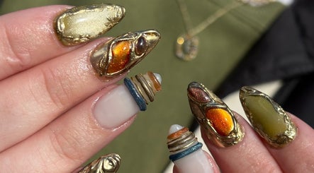 Intricate golden nail art byphoeb in Cardiff, Wales, GB, featuring metallic accents and bold designs.