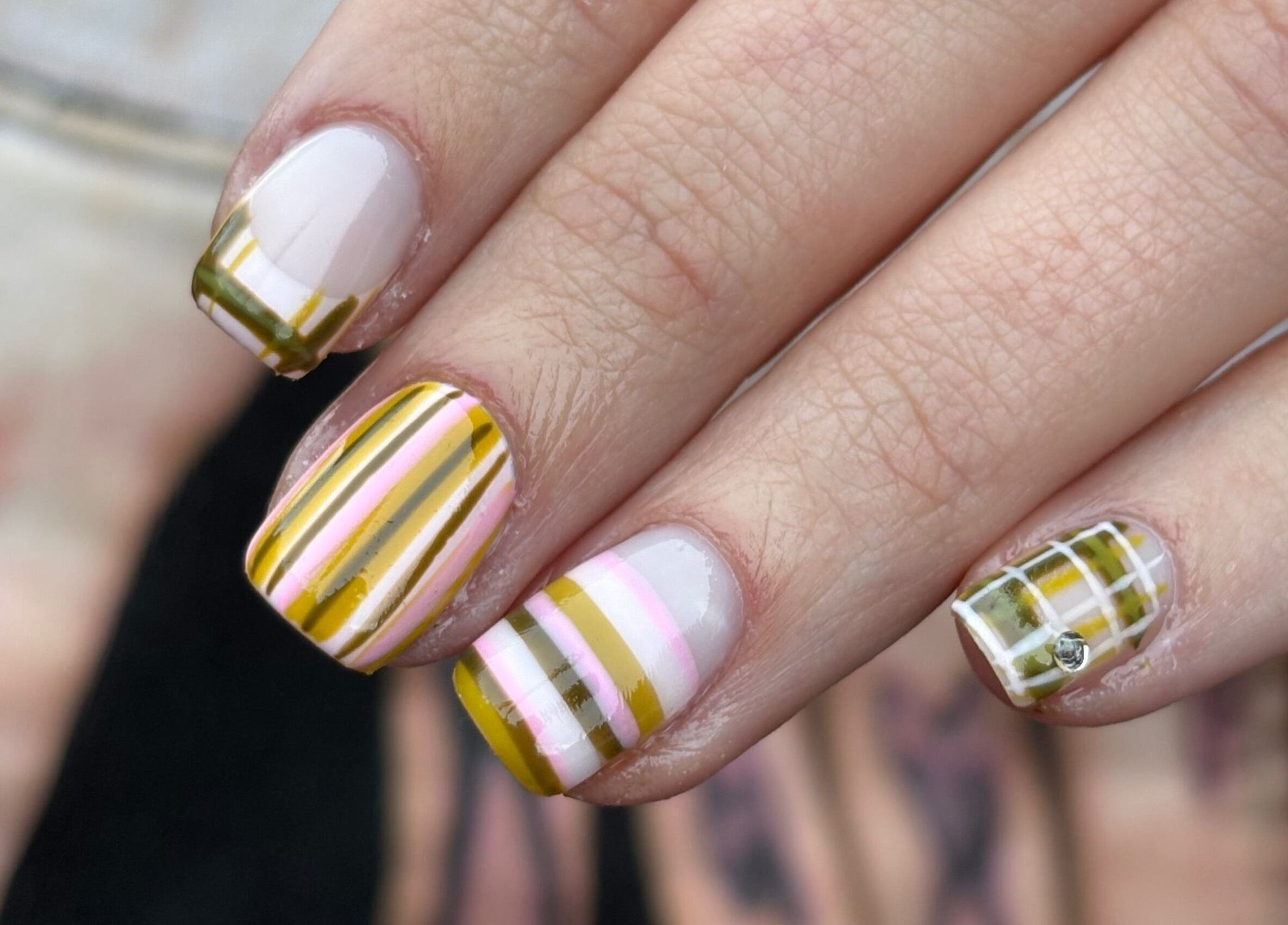 Stylish striped nail art at byphoeb, Cardiff, Wales, GB. Featuring vibrant yellow and pink design.