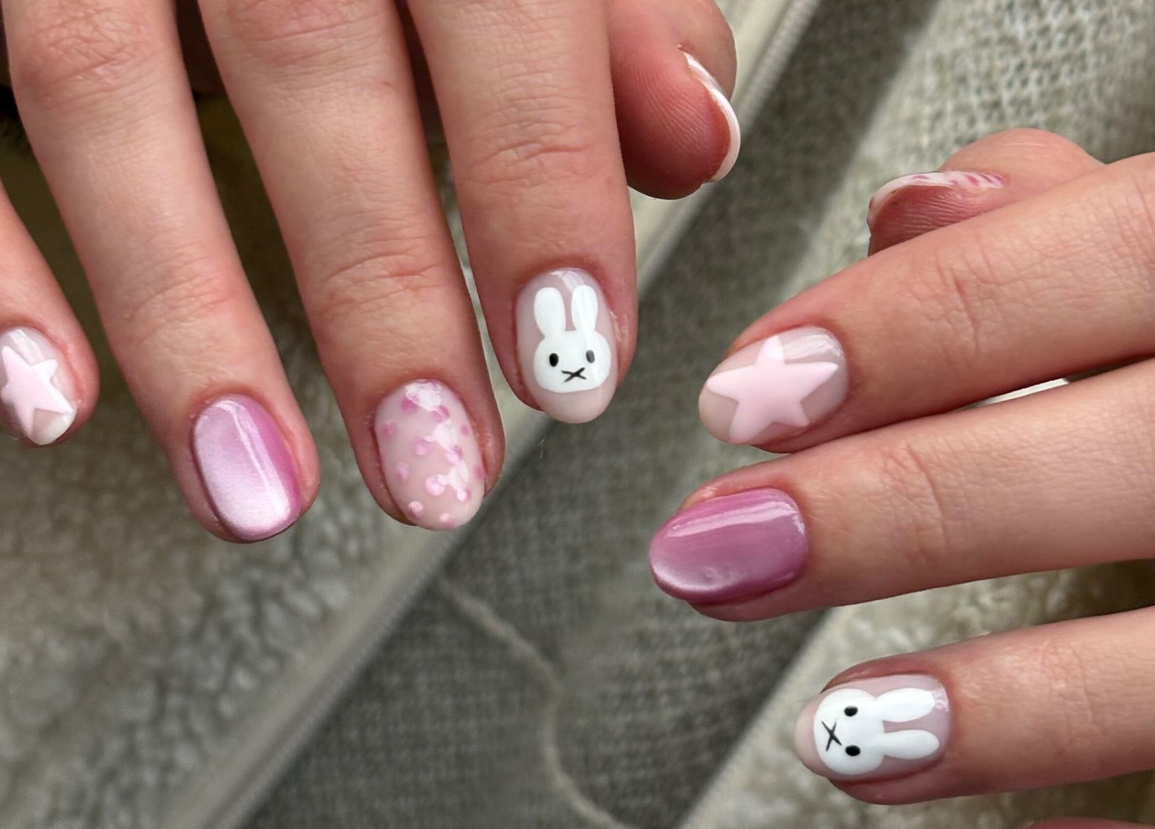 Playful rabbit nail art at byphoeb, Cardiff, Wales, GB showcasing creativity in pink star patterns.