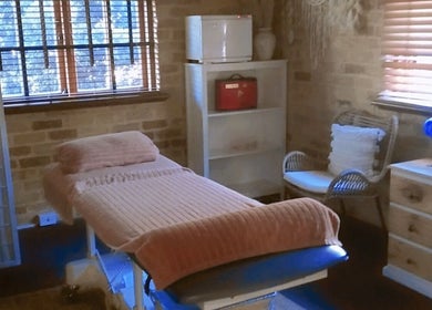 Massage room at Recharge Remedial And Sports Massage, Perth, WA, with cozy bed and serene decor.