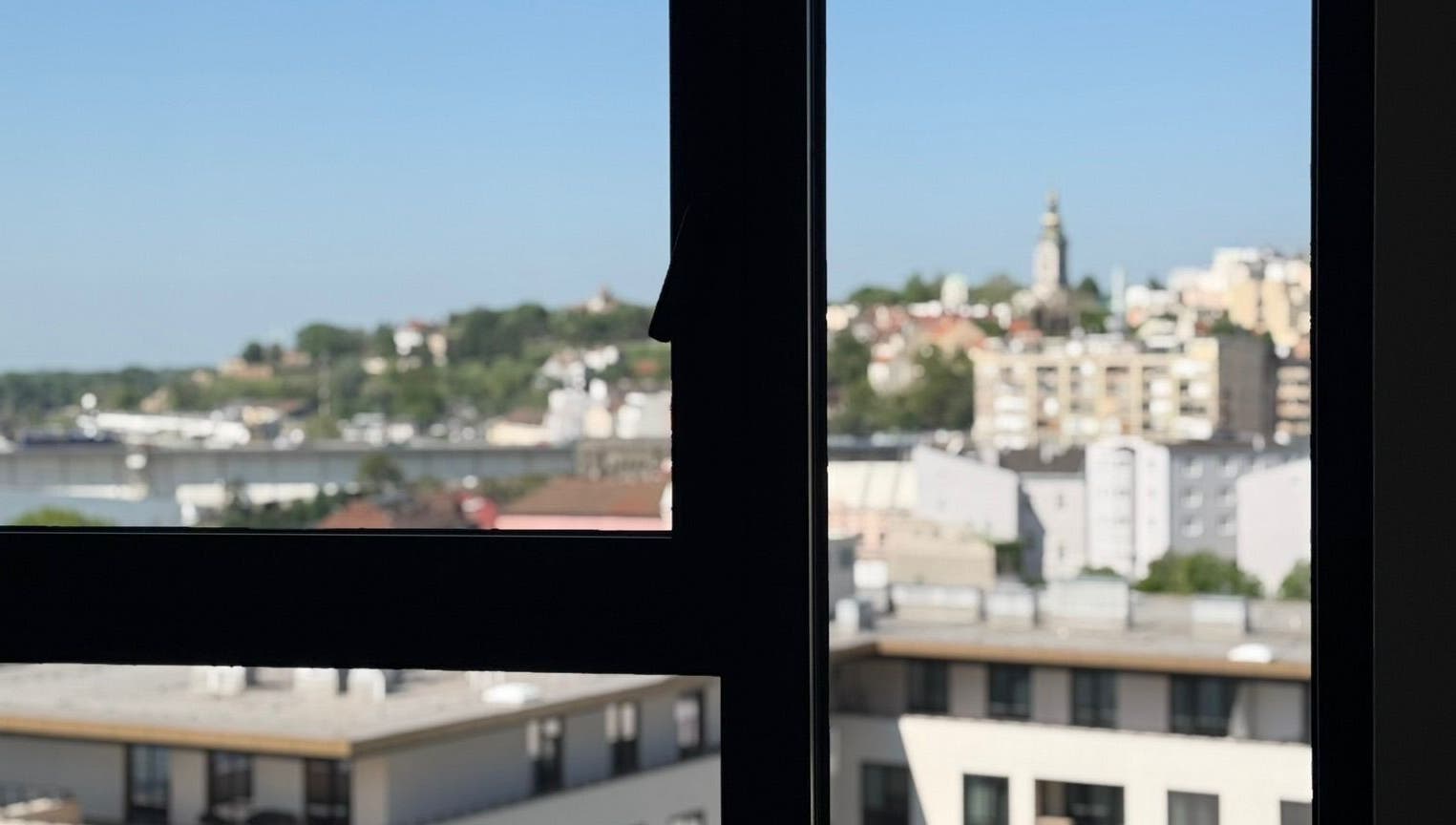 Pogled kroz prozor AMP - studio za nokte na Beograd, RS s urbanim pejsažem.