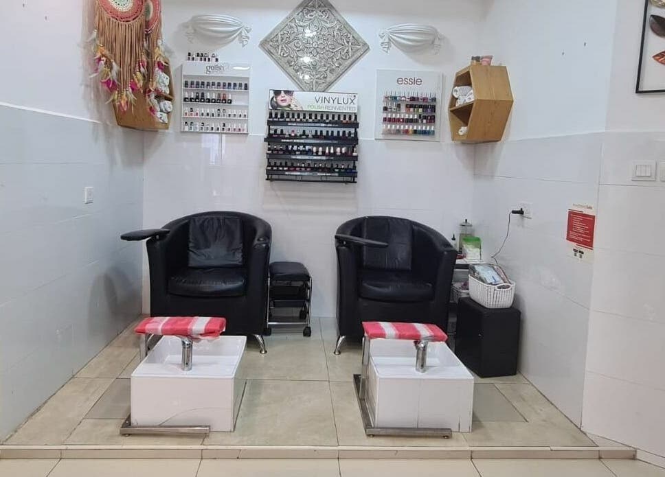 Relaxing pedicure area at Pretty Eye Ladies Saloon, Dubai, AE, showcasing comfortable chairs and nail polish displays.