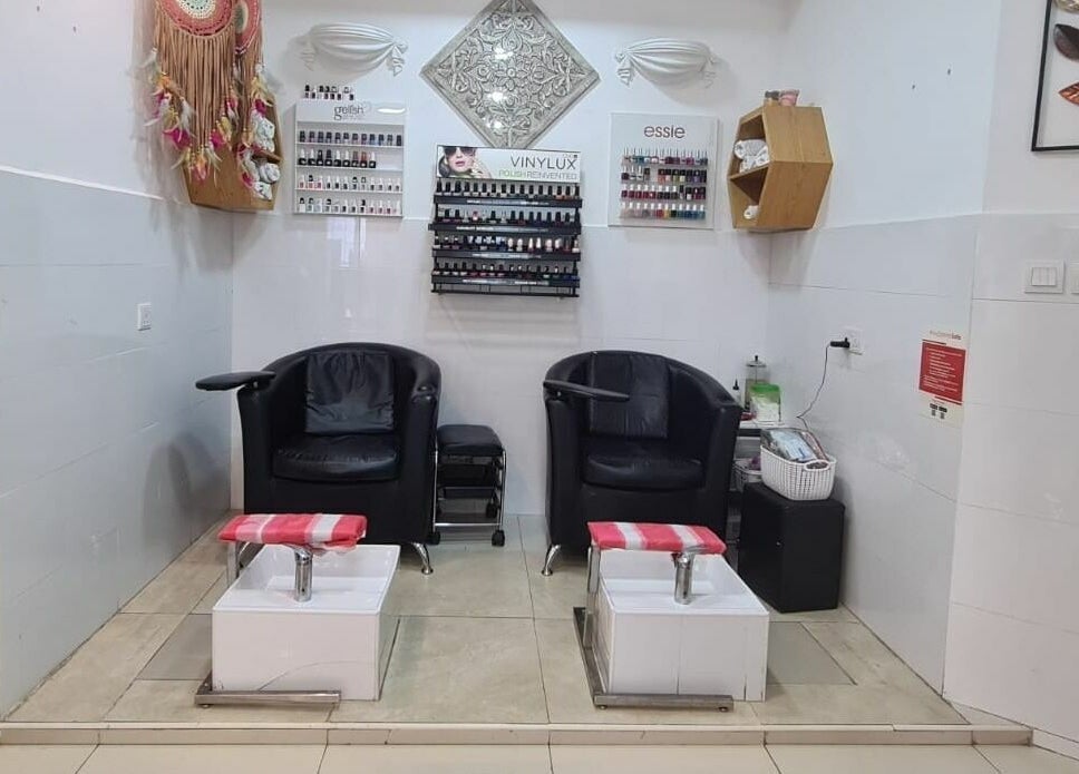 Relaxing pedicure area at Pretty Eye Ladies Saloon, Dubai, AE, showcasing comfortable chairs and nail polish displays.