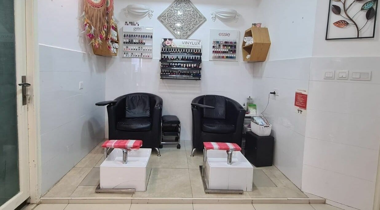 Relaxing pedicure area at Pretty Eye Ladies Saloon, Dubai, AE, showcasing comfortable chairs and nail polish displays.