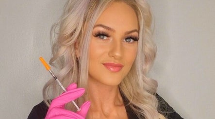 Professional injector smiling at GCI Advanced Aesthetics, Aberdeen, Scotland, GB, holding a syringe with care.