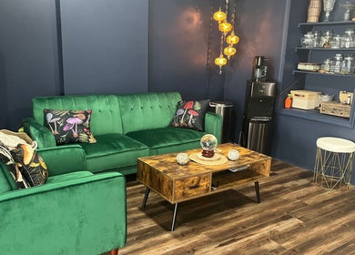 Elegant lounge at The Root Wellness Center, Caro, Michigan, US, with a plush green sofa and ambient lighting.