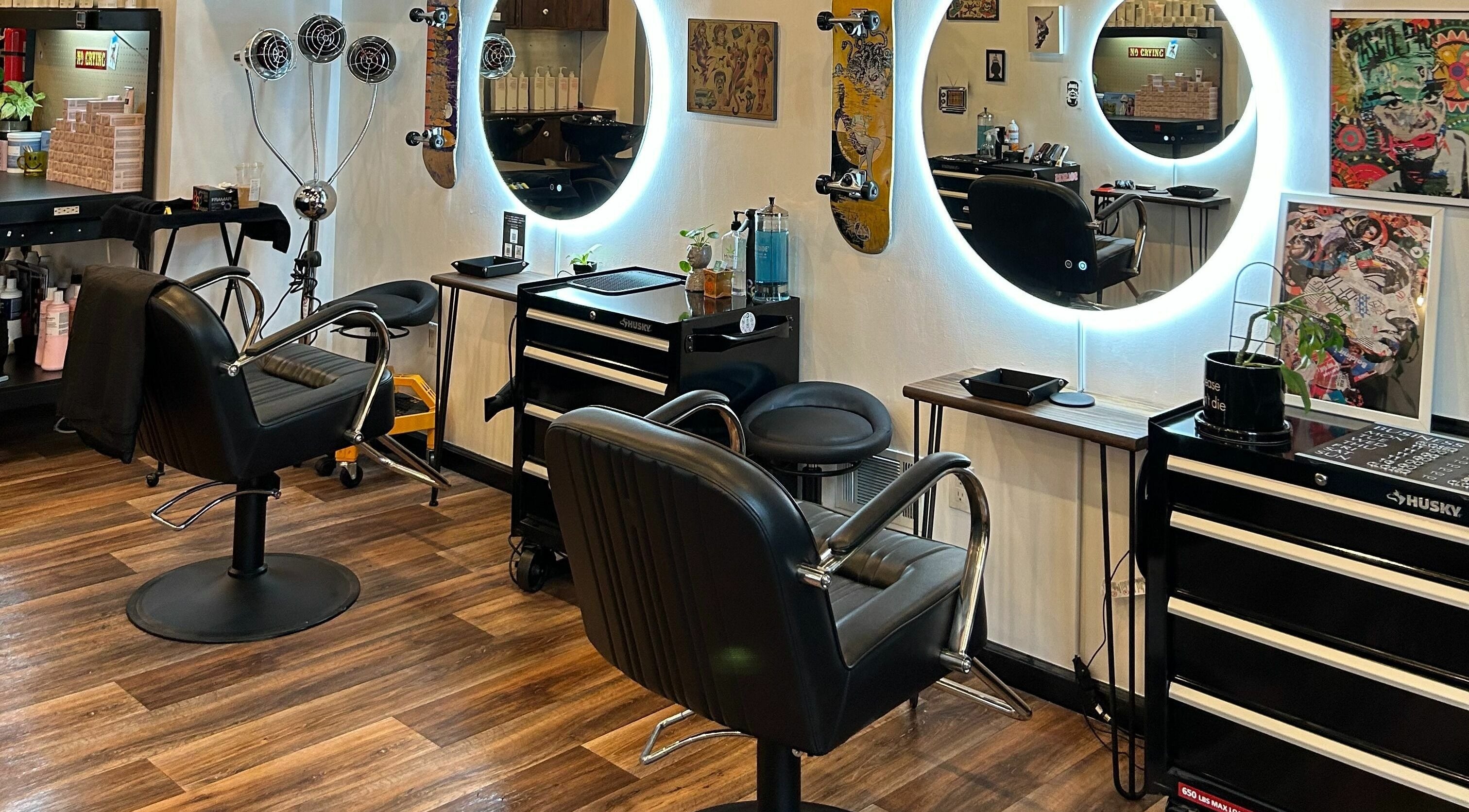 Sleek interior of The Workshop Hair Studio in Lancaster, Pennsylvania, US, showcasing modern styling chairs and mirrors.
