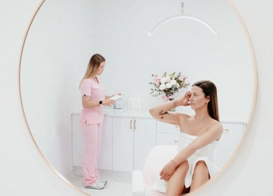 Elegant spa setting at About Face, Taree, New South Wales, AU with a client in white and staff in pink.