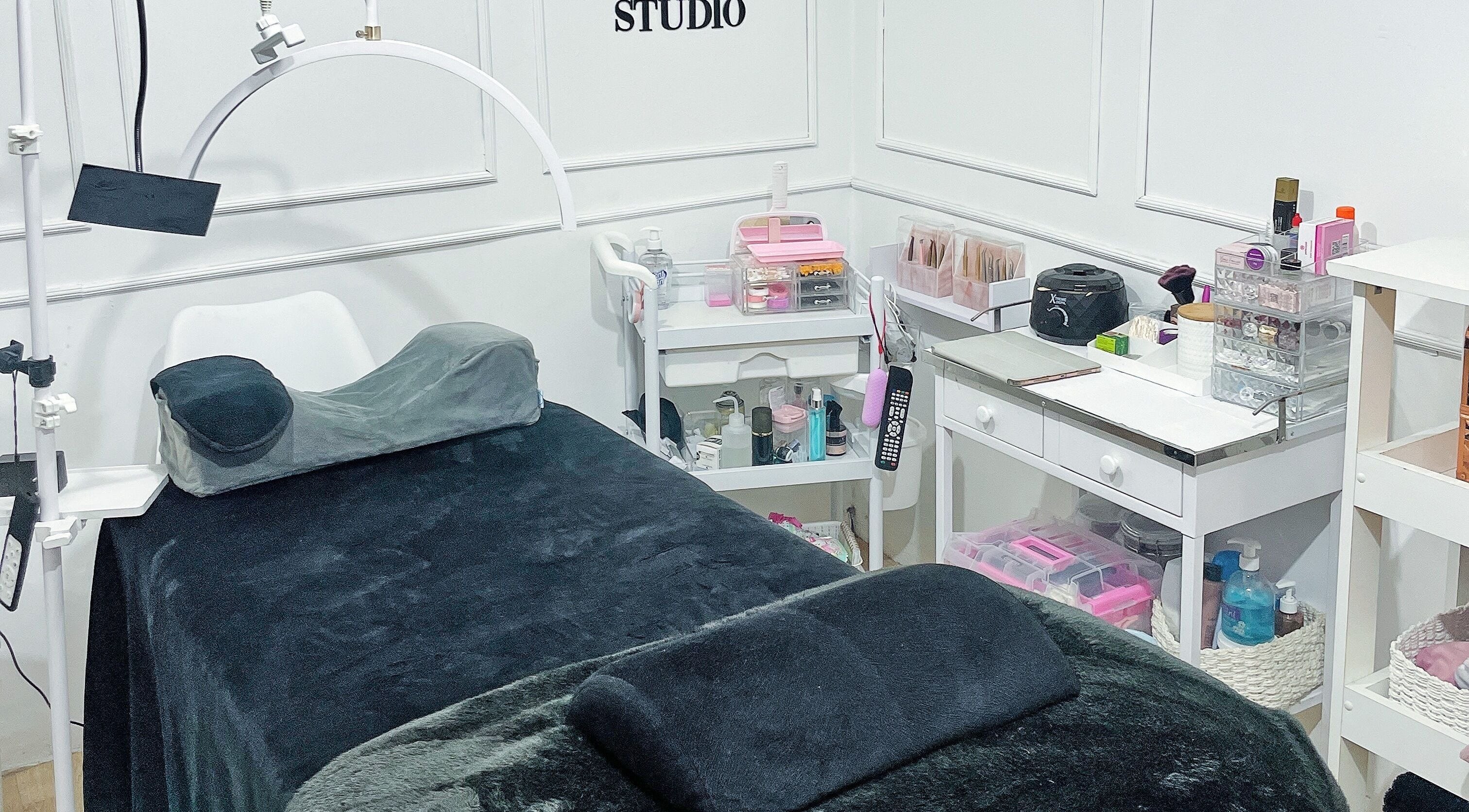 Sala de tratamiento en MO Studio, Callao, con camilla negra y productos de belleza organizados.