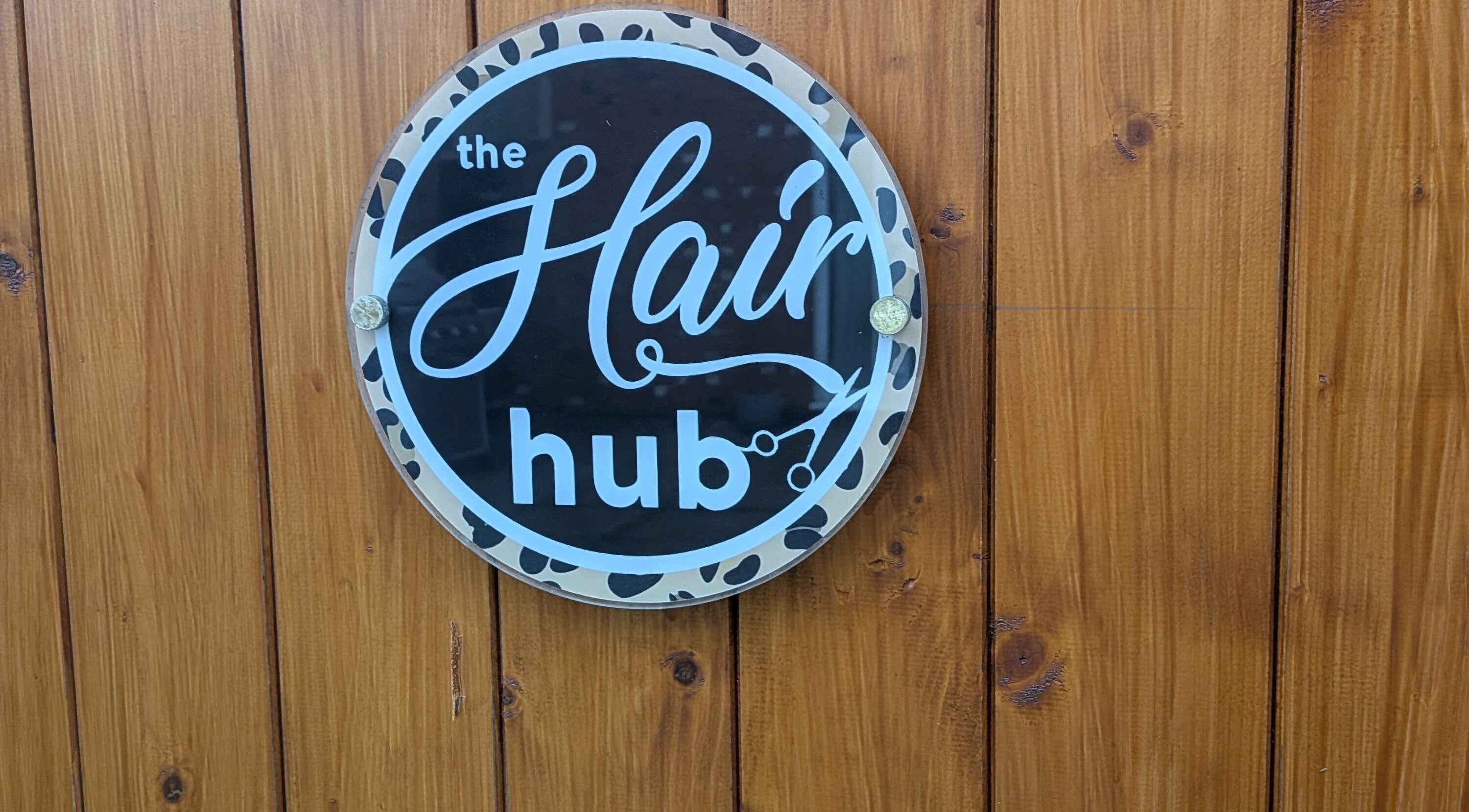 The Hair Hub signboard in Wakefield, England, GB on a wooden wall.