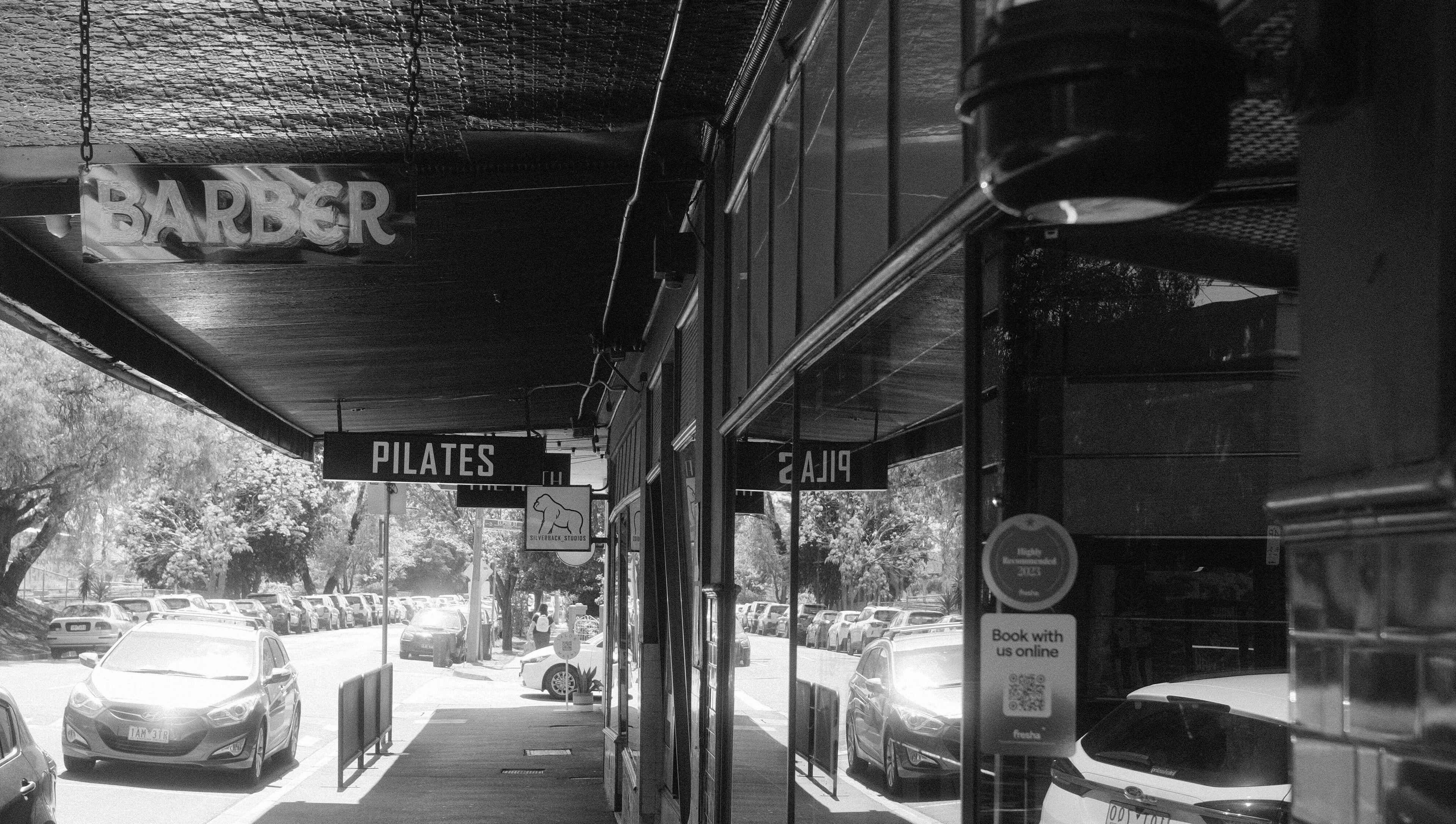 Street view with Lighthouse Barbers in Melbourne, Victoria, AU, offering a welcoming entrance.