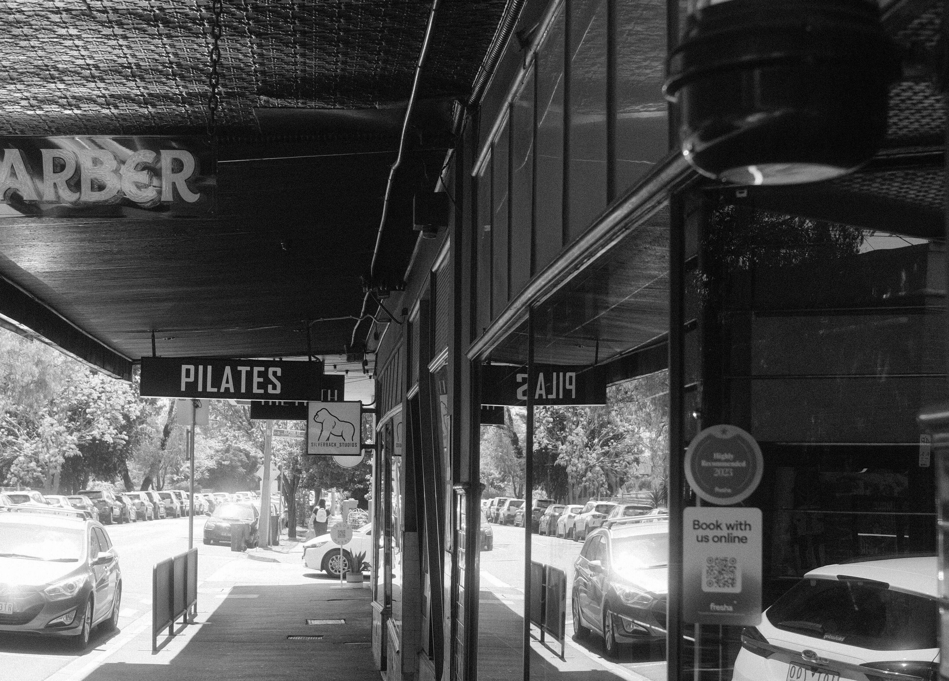 Street view with Lighthouse Barbers in Melbourne, Victoria, AU, offering a welcoming entrance.