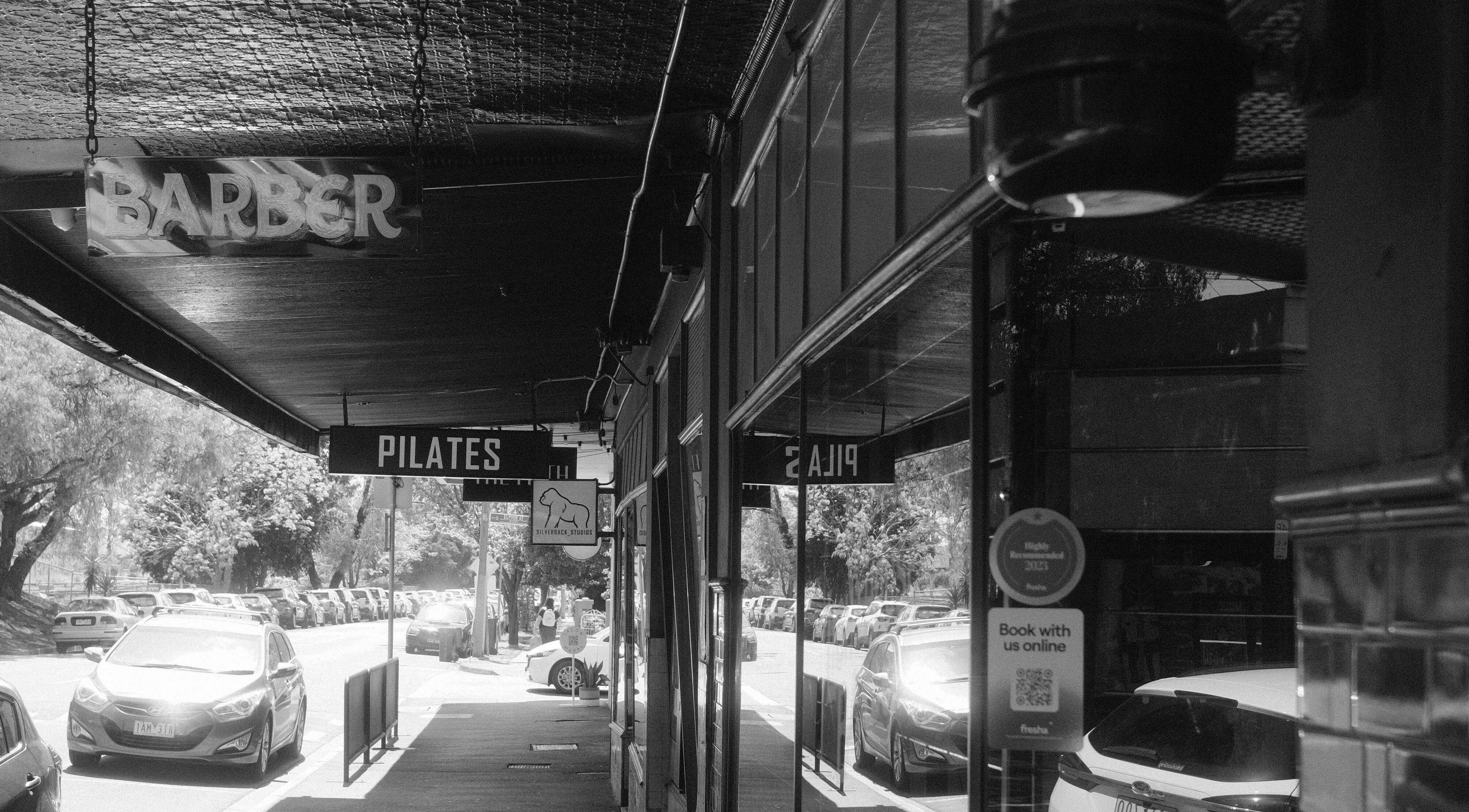 Street view with Lighthouse Barbers in Melbourne, Victoria, AU, offering a welcoming entrance.
