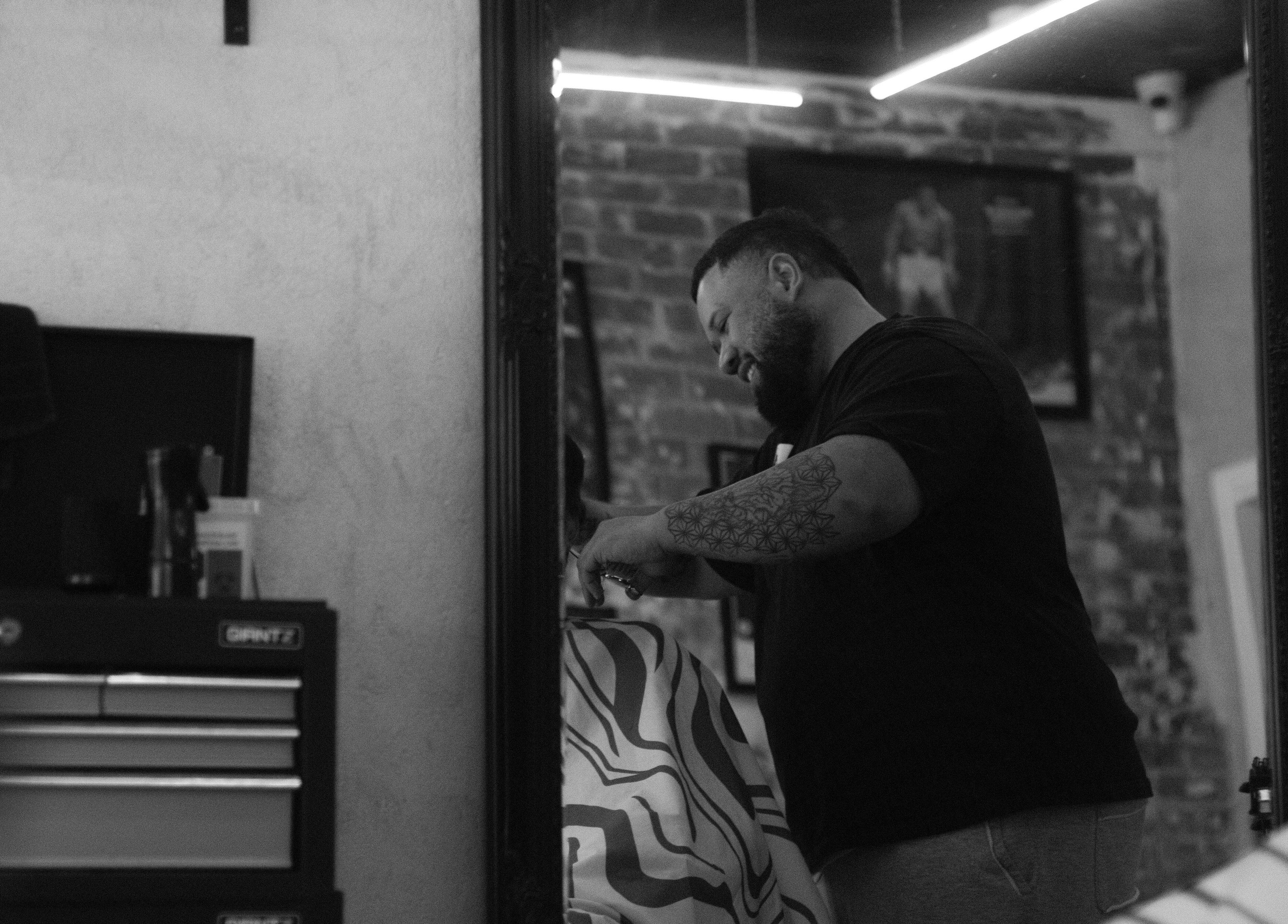 Barber styling hair at Lighthouse Barbers, Melbourne, Victoria, AU, in a chic setting.