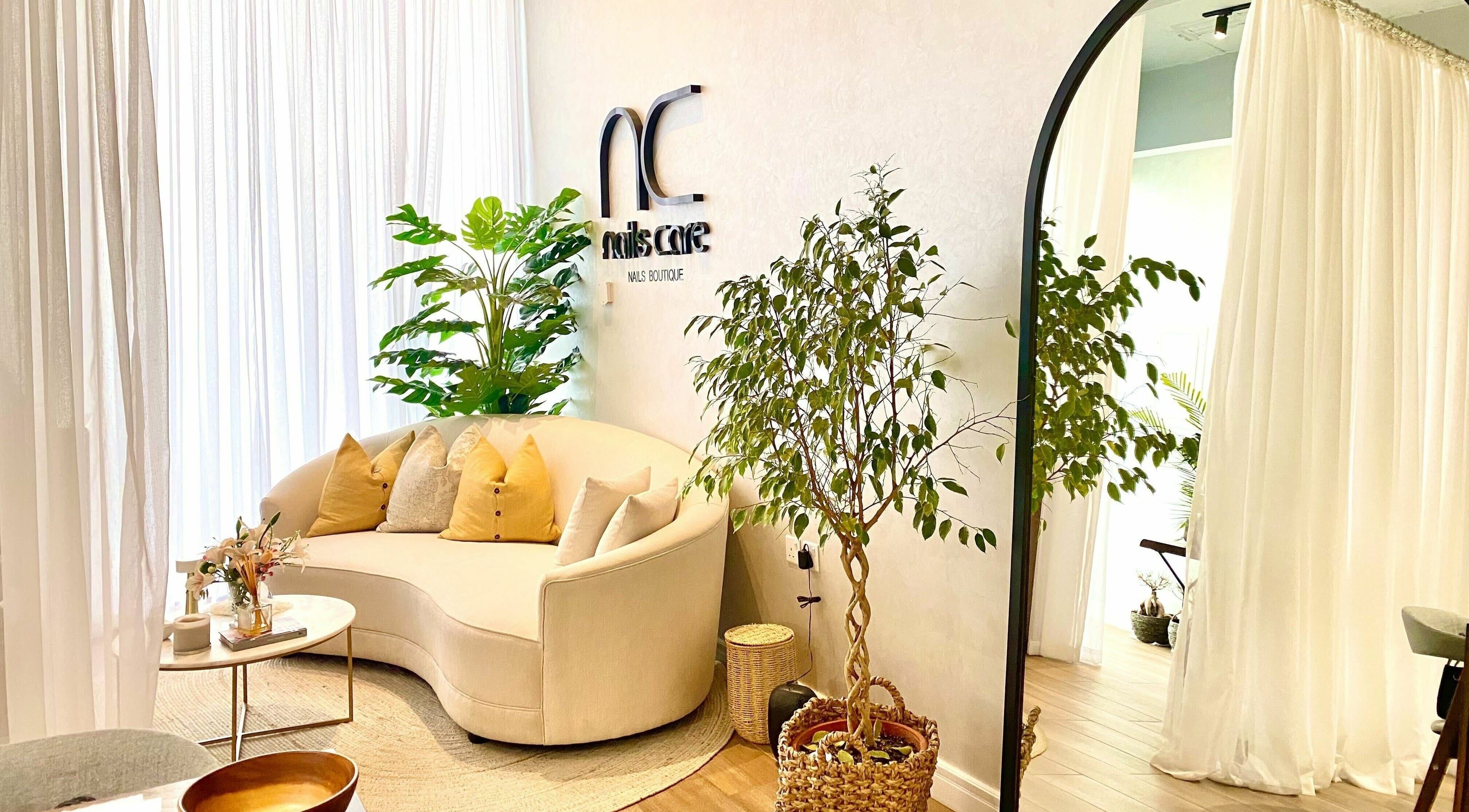 Cozy seating area in Nails Care | صالون عناية الأظافر, Riyadh, featuring elegant decor plants and soft lighting.