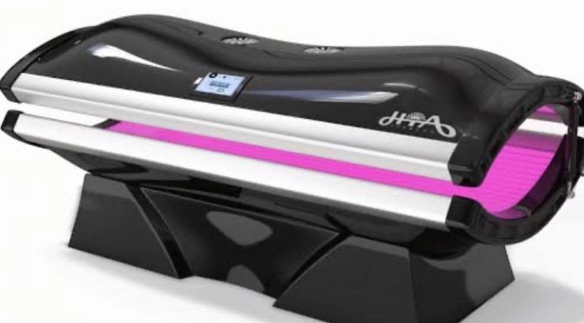 High-tech tanning bed at CS Tan, Melbourne, Victoria, AU. Sleek design with vibrant purple lighting.