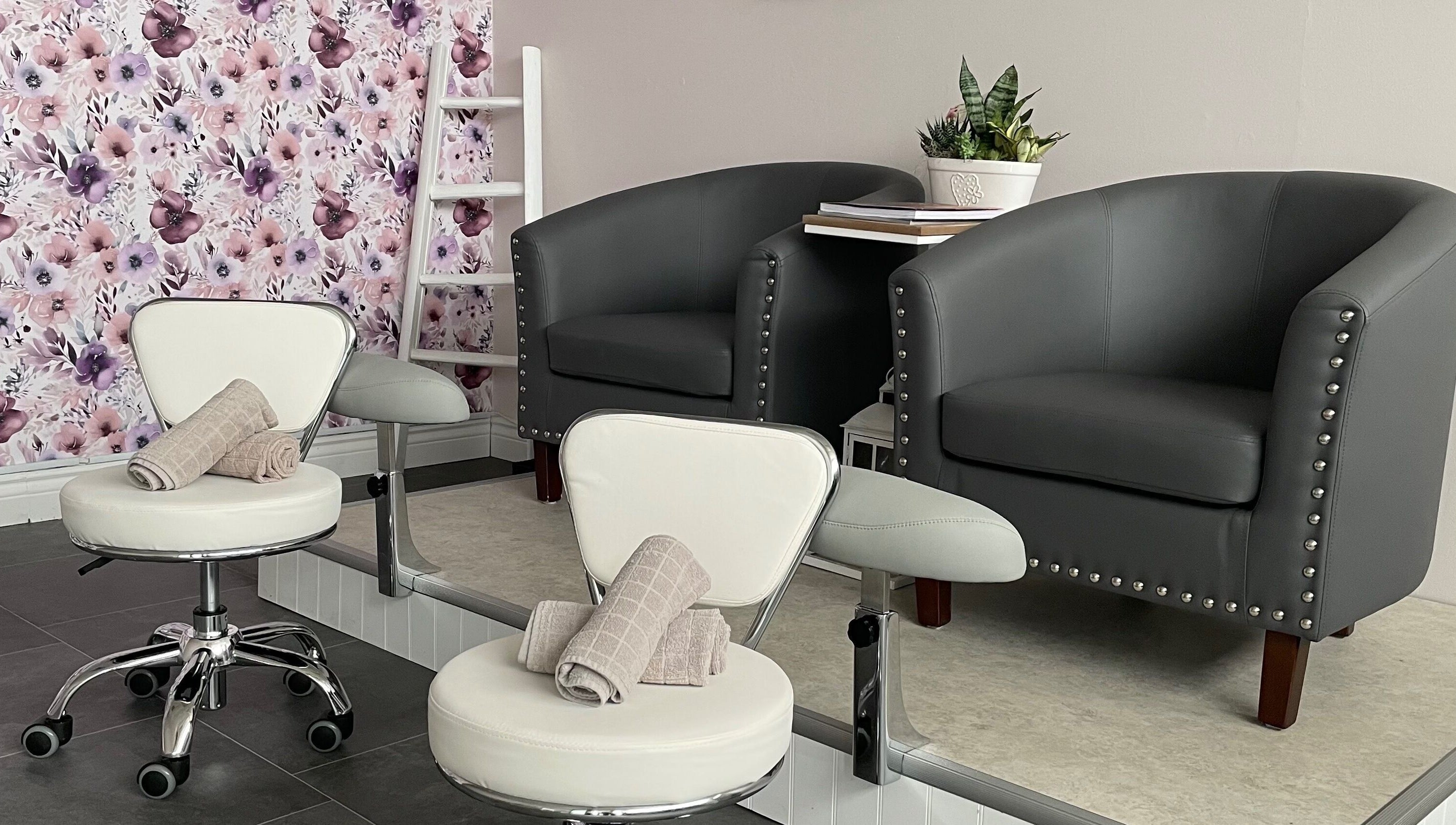 Cozy seating area at Sundara Spa, Midland, Ontario, CA with floral wall and elegant chairs.