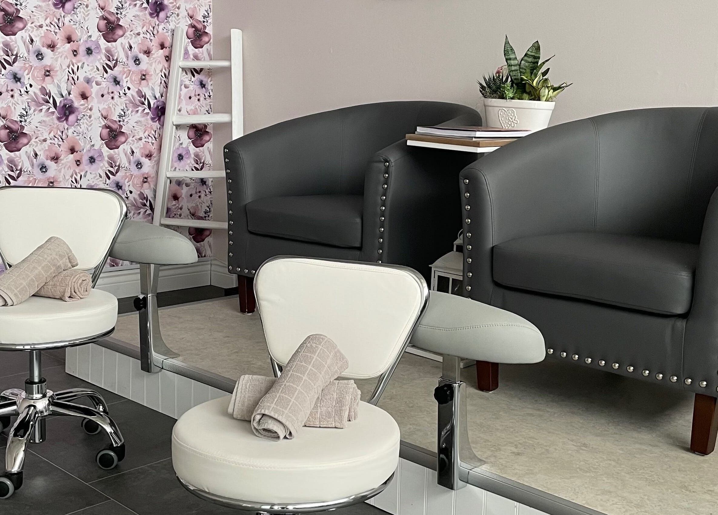 Cozy seating area at Sundara Spa, Midland, Ontario, CA with floral wall and elegant chairs.