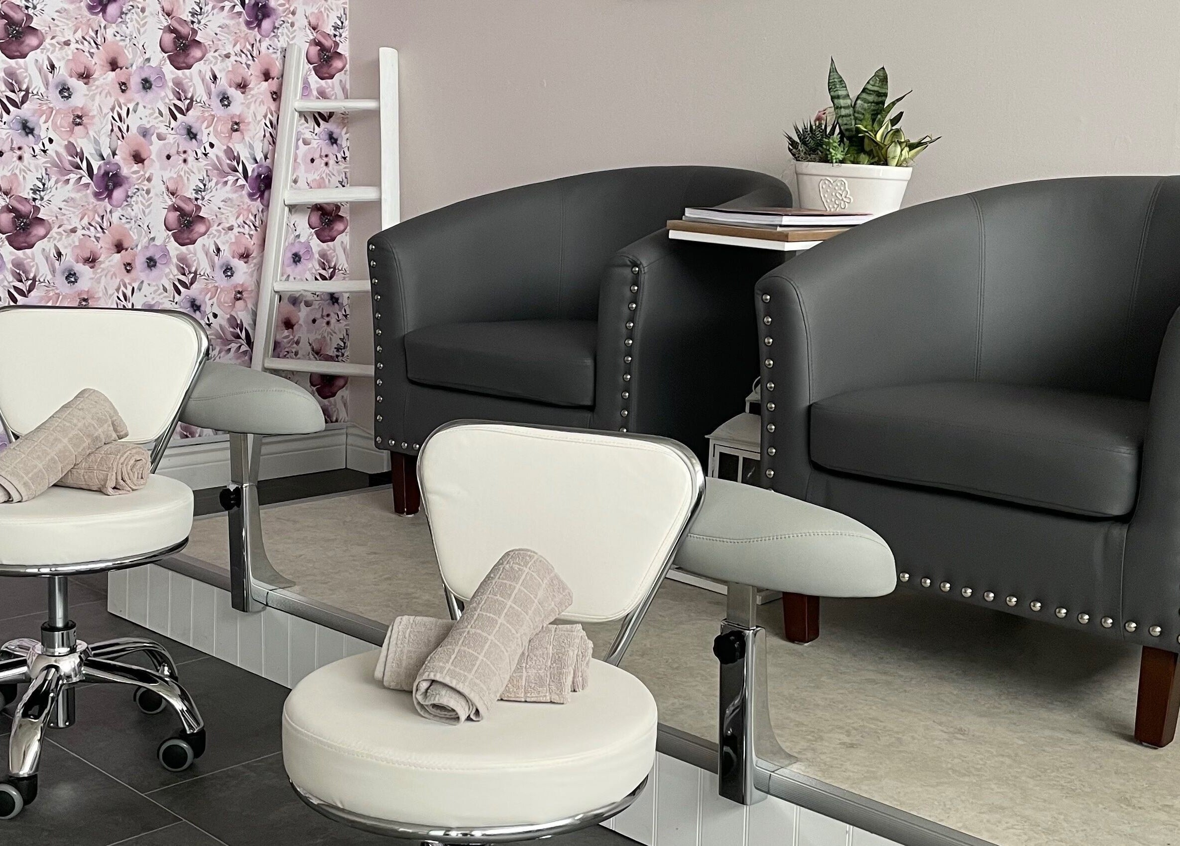 Cozy seating area at Sundara Spa, Midland, Ontario, CA with floral wall and elegant chairs.
