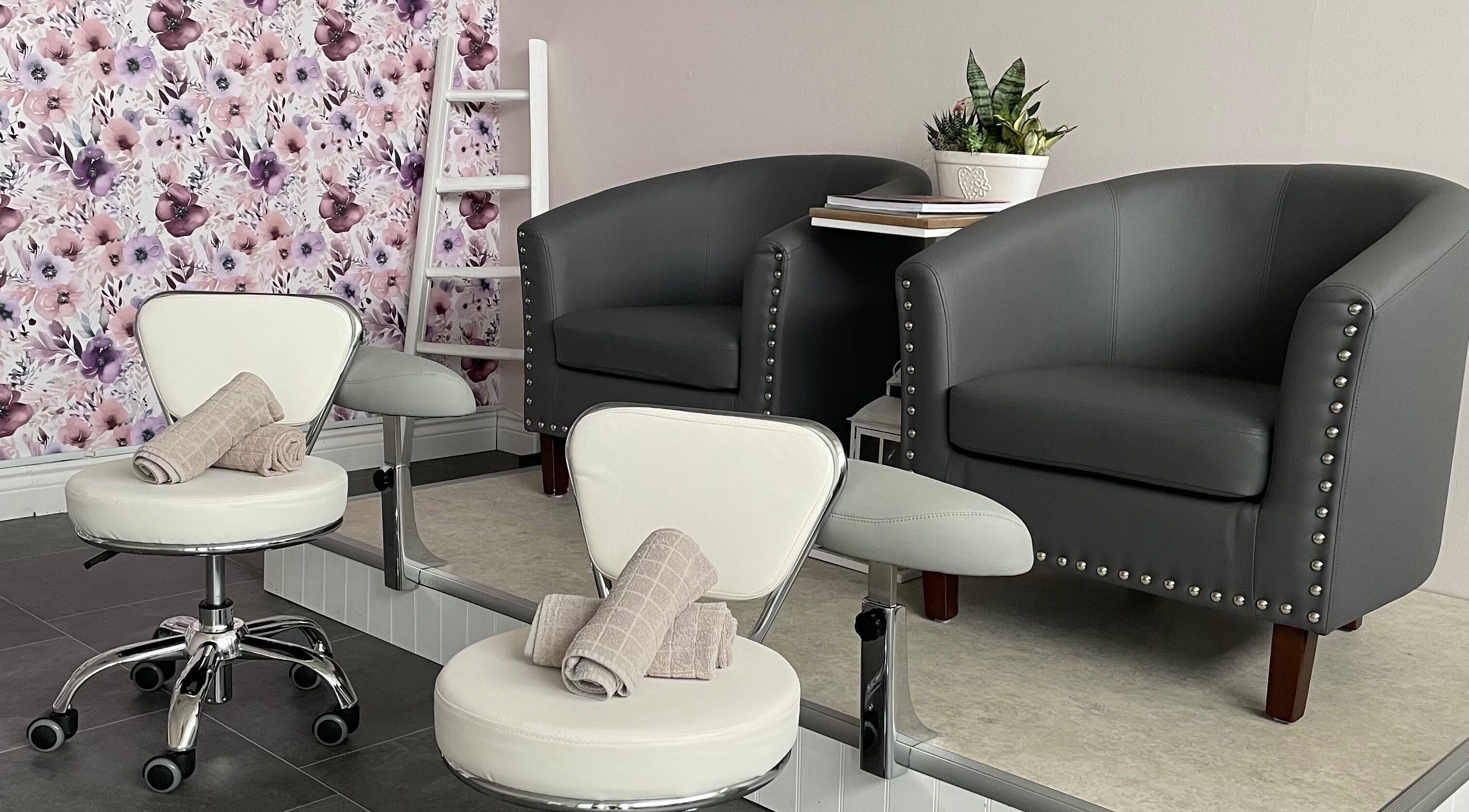 Cozy seating area at Sundara Spa, Midland, Ontario, CA with floral wall and elegant chairs.
