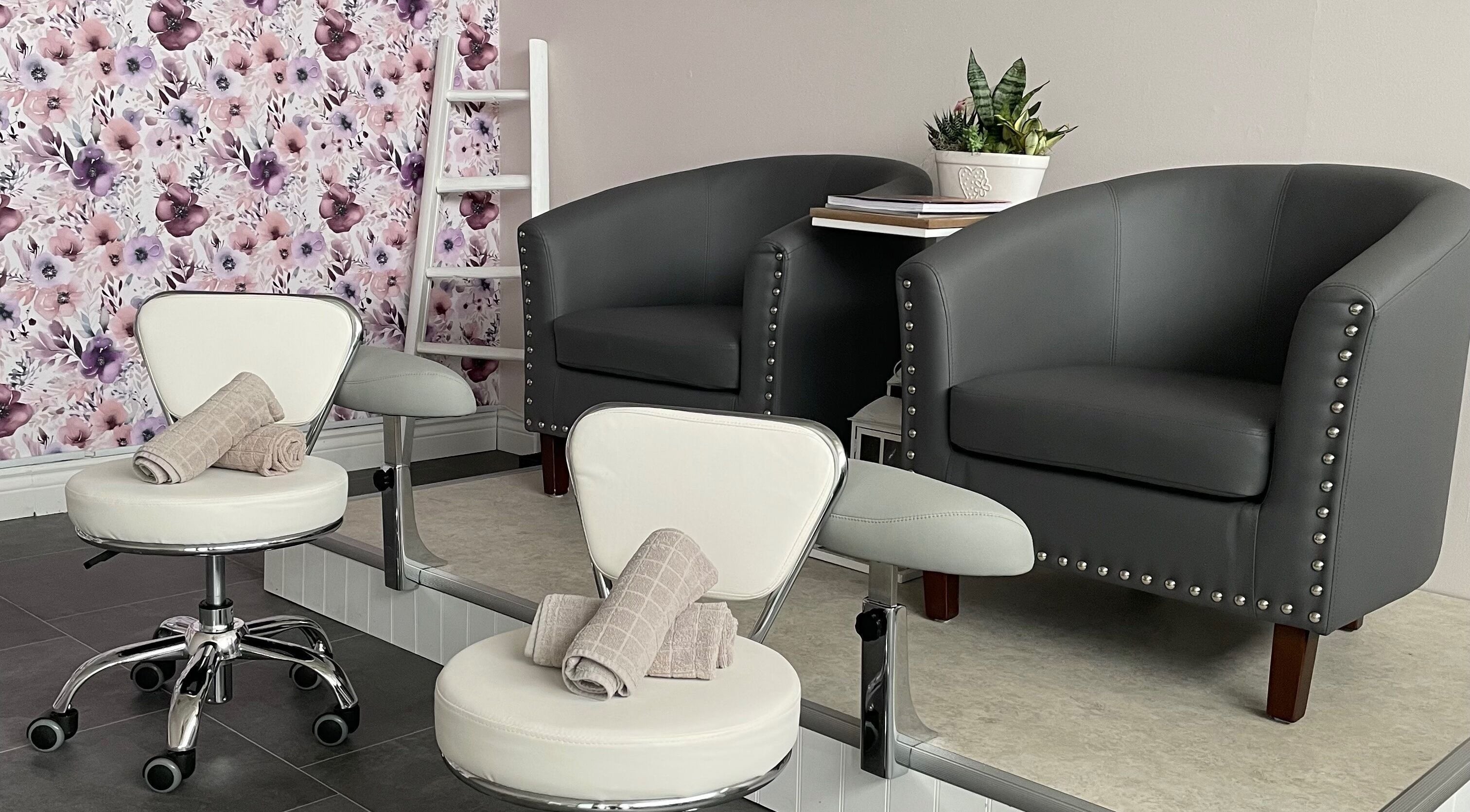Cozy seating area at Sundara Spa, Midland, Ontario, CA with floral wall and elegant chairs.