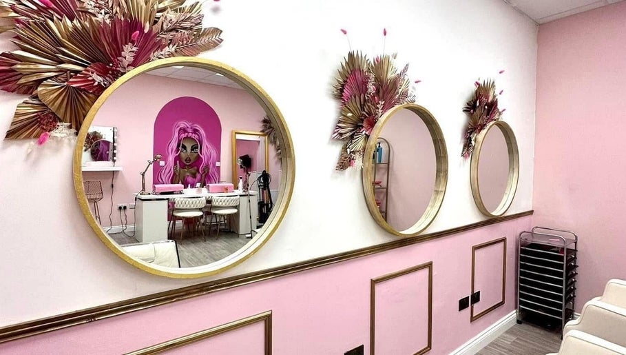 Stylish interior of Hair By Ellie in Sunderland, England, with decorative mirrors and vibrant pink accents.