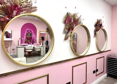 Stylish interior of Hair By Ellie in Sunderland, England, with decorative mirrors and vibrant pink accents.