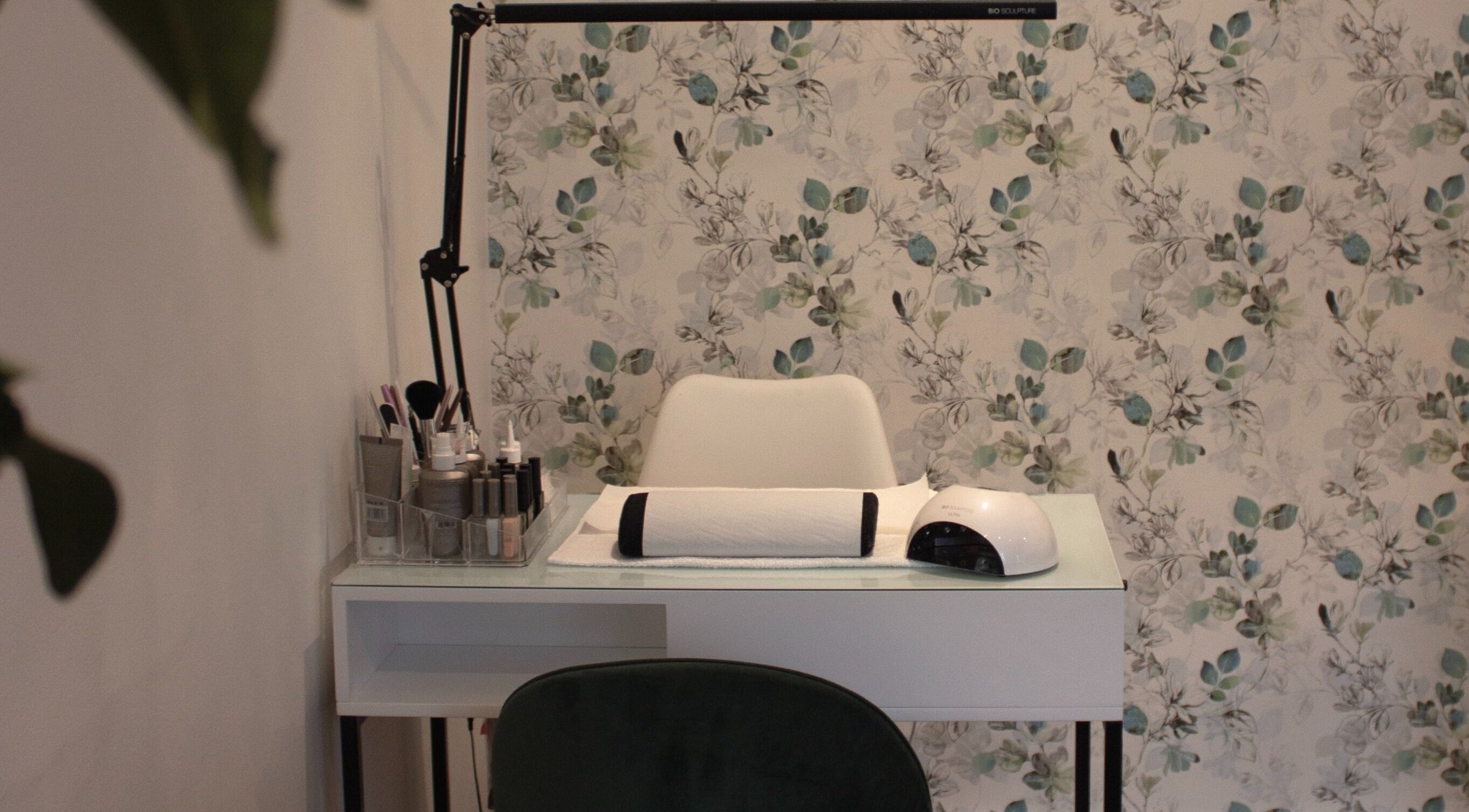 Manicure station at The Skin Firm in Cape Town, Western Cape, ZA featuring intricate floral wallpaper.