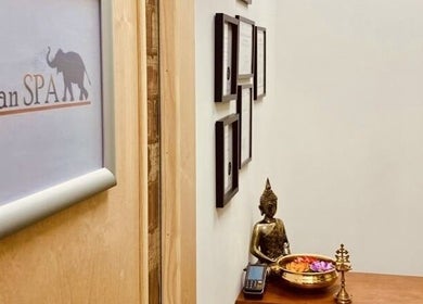 Entrance decor of The Indian Spa, featuring a Buddha statue and wall art in Cardiff, Wales, GB.