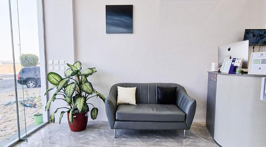 Elegant lobby at Salon and Spa Elegant, Al Mubarraz, Eastern Province, SA featuring sleek grey couch and plant.