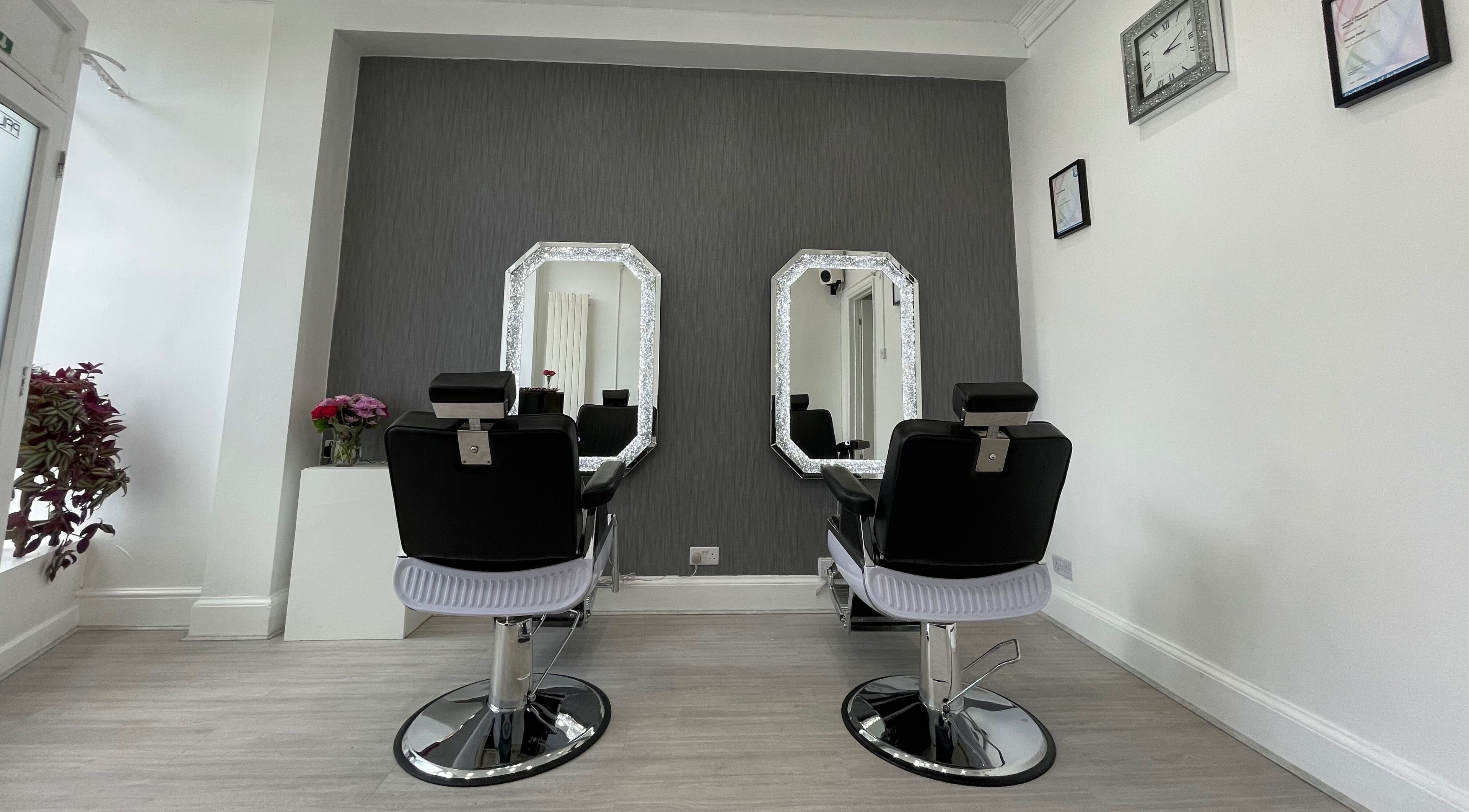 Stylish salon interior of Shaz Hair & Beauty in Leicester, England, GB featuring chic black chairs and mirrors.