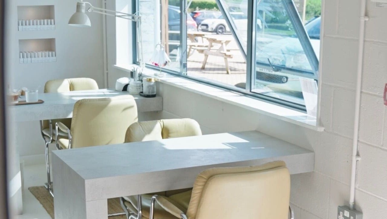 Bright nail salon interior at Liwa Nails, Wadebridge, England, GB with cozy seating and natural light.