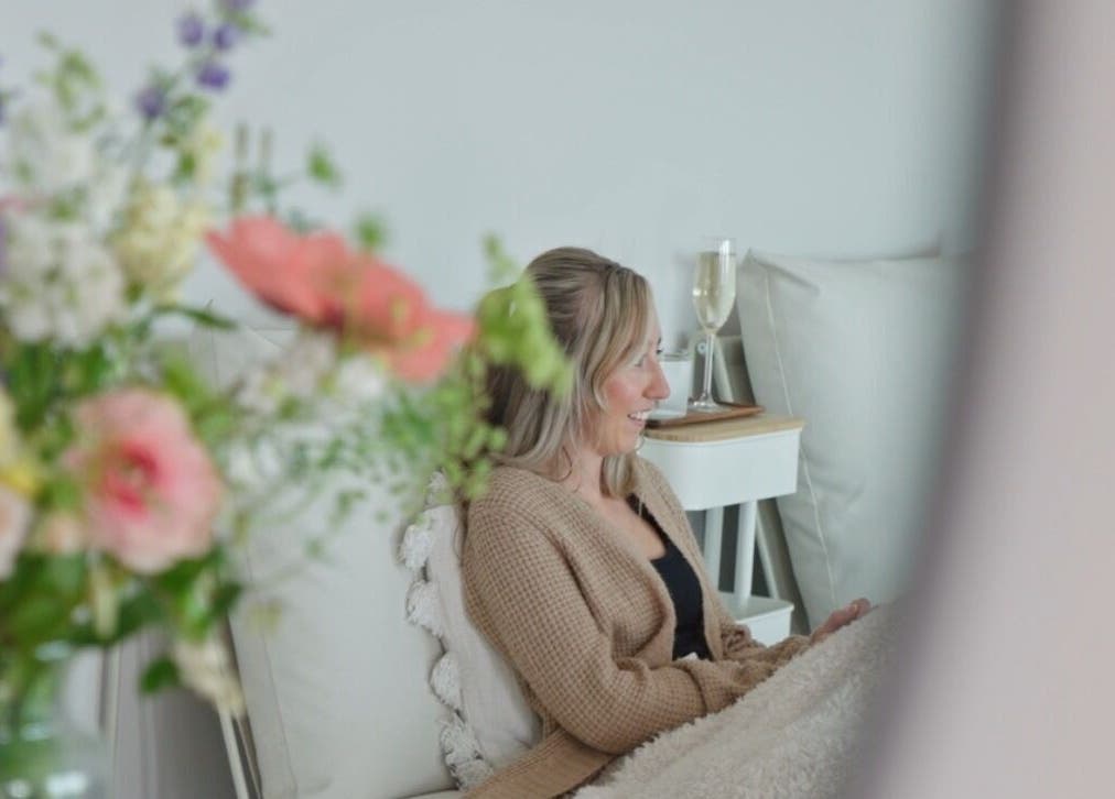 Woman relaxing at Liwa nails, Wadebridge, England, GB with flowers and champagne.