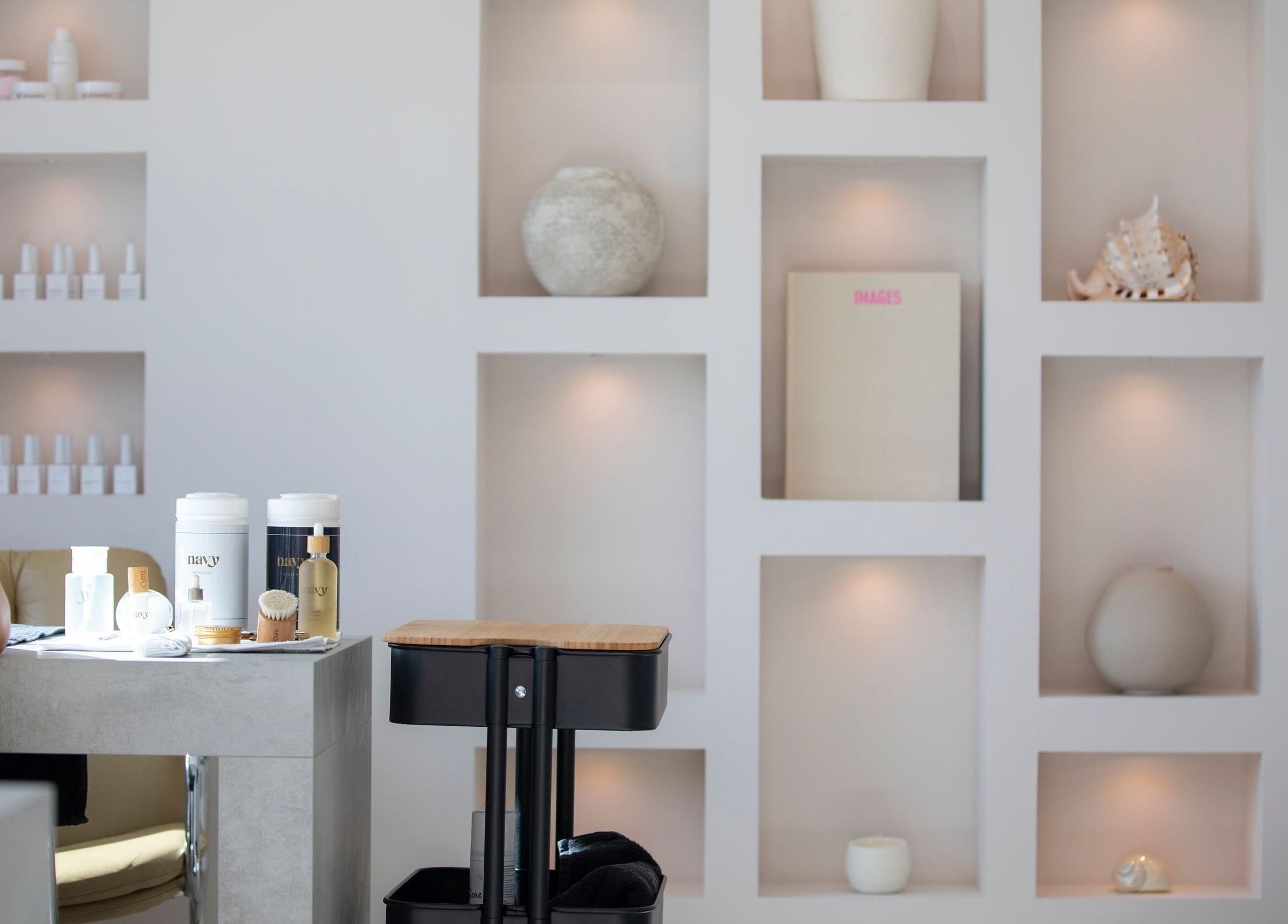 Modern nail salon interior at Liwa nails, Wadebridge, England, GB, showcasing decorative shelving and beauty products.