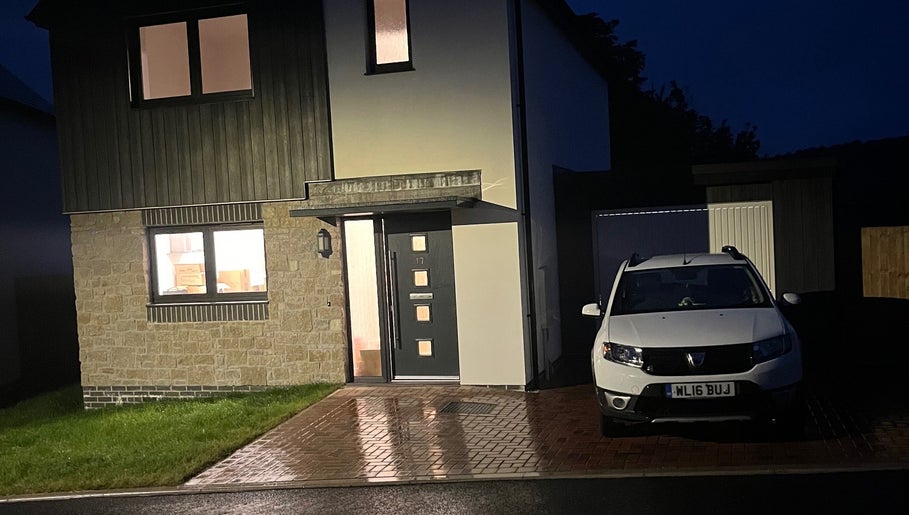 Exterior view of Fletcher Beauty in Lanner, England, showcasing modern design at night with parked car.