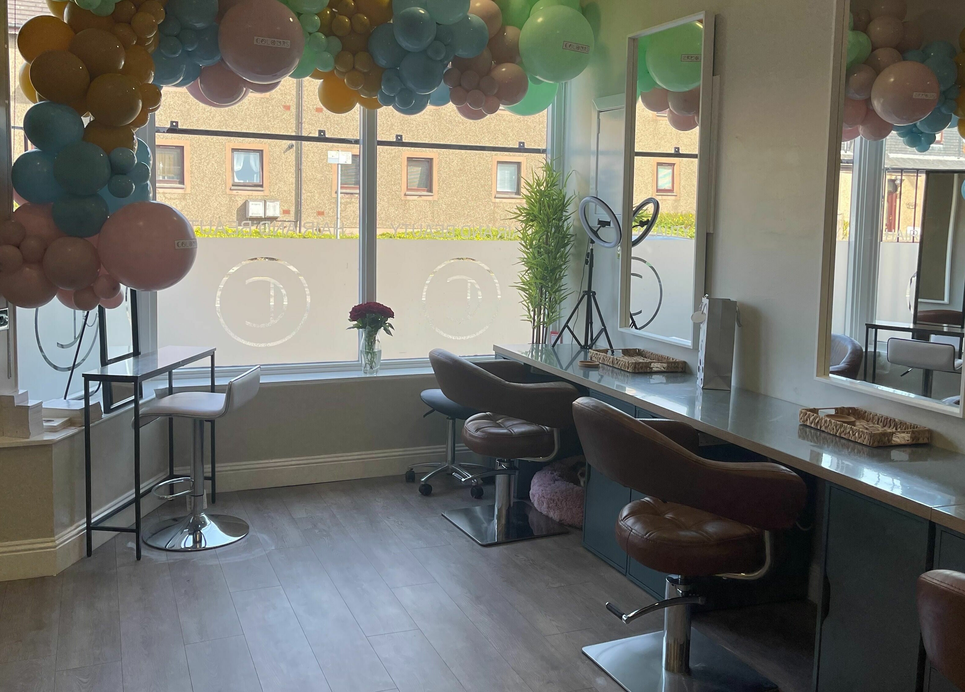 Modern salon interior at Colours Falkirk, Falkirk, Scotland, GB, featuring chic chairs and large windows.