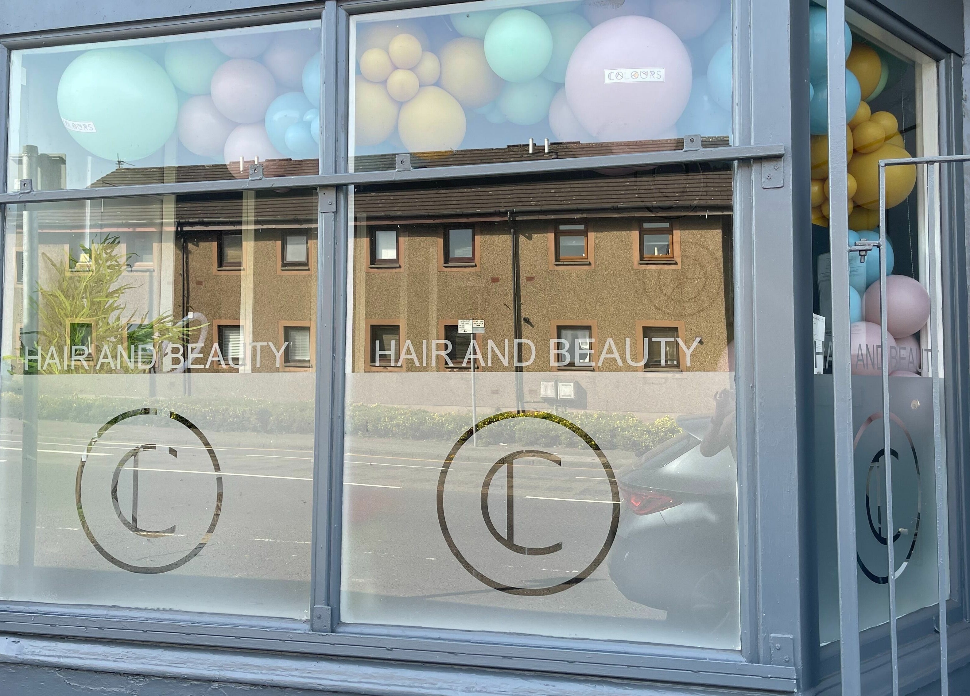 Front window of Colours Falkirk, a beauty venue in Falkirk, Scotland, GB with pastel balloon display.