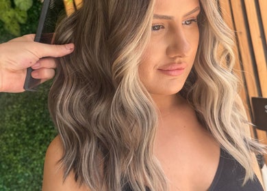 A stylist combs elegant blonde waves at STUDIO twenty two, Pontypool, Wales, GB.