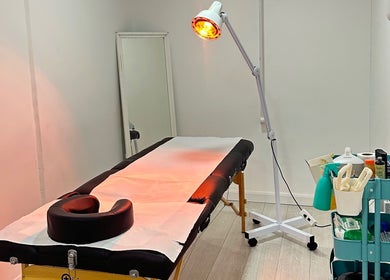 Therapy room at Cupping Clinic, London, England, GB featuring massage table and warm lighting setup.