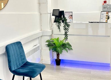 Welcoming reception area at Cupping Clinic in London, England, GB with blue chairs and greenery.