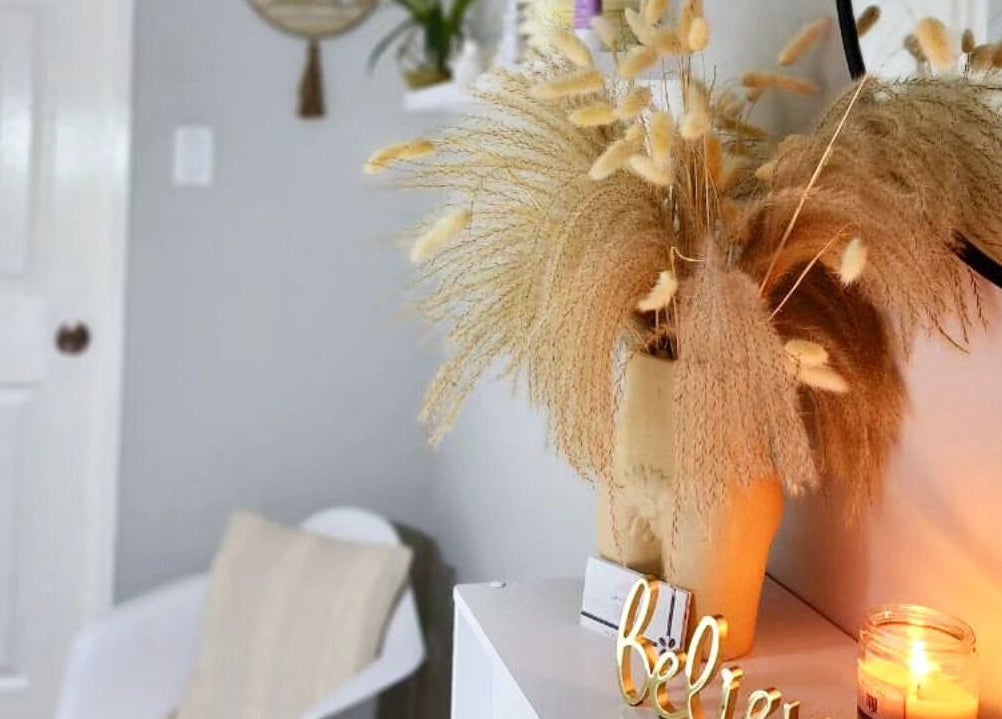 Cozy corner at Smooth n Bare, Kingston, St. Andrew Parish, JM featuring dried florals and a lit candle.