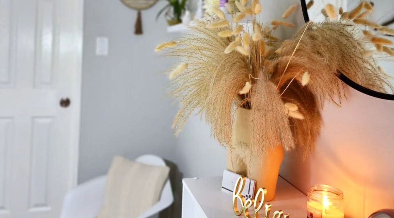 Cozy corner at Smooth n Bare, Kingston, St. Andrew Parish, JM featuring dried florals and a lit candle.