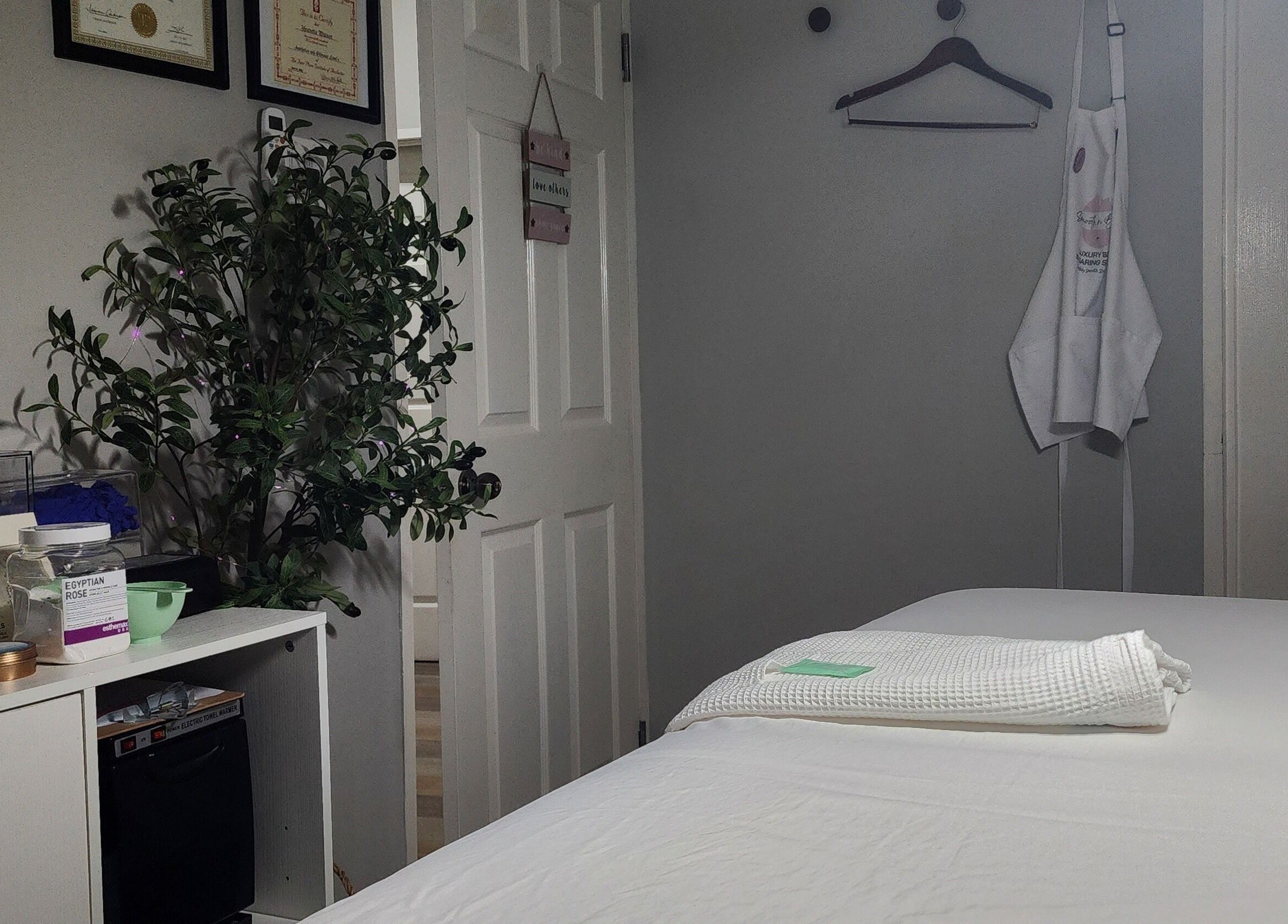 Relaxing spa room at Smooth n Bare, Kingston, St. Andrew Parish, JM with treatment bed and lush greenery.