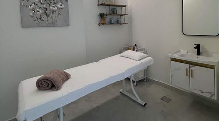 Tranquil treatment room at Enana Ladies Beauty Salon, Dubai, Dubai, AE with a massage bed and modern sink.