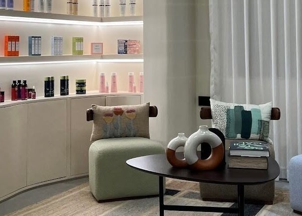 Inviting seating and decor at SOLO, Ajman, Ajman, AE with shelves of beauty products.
